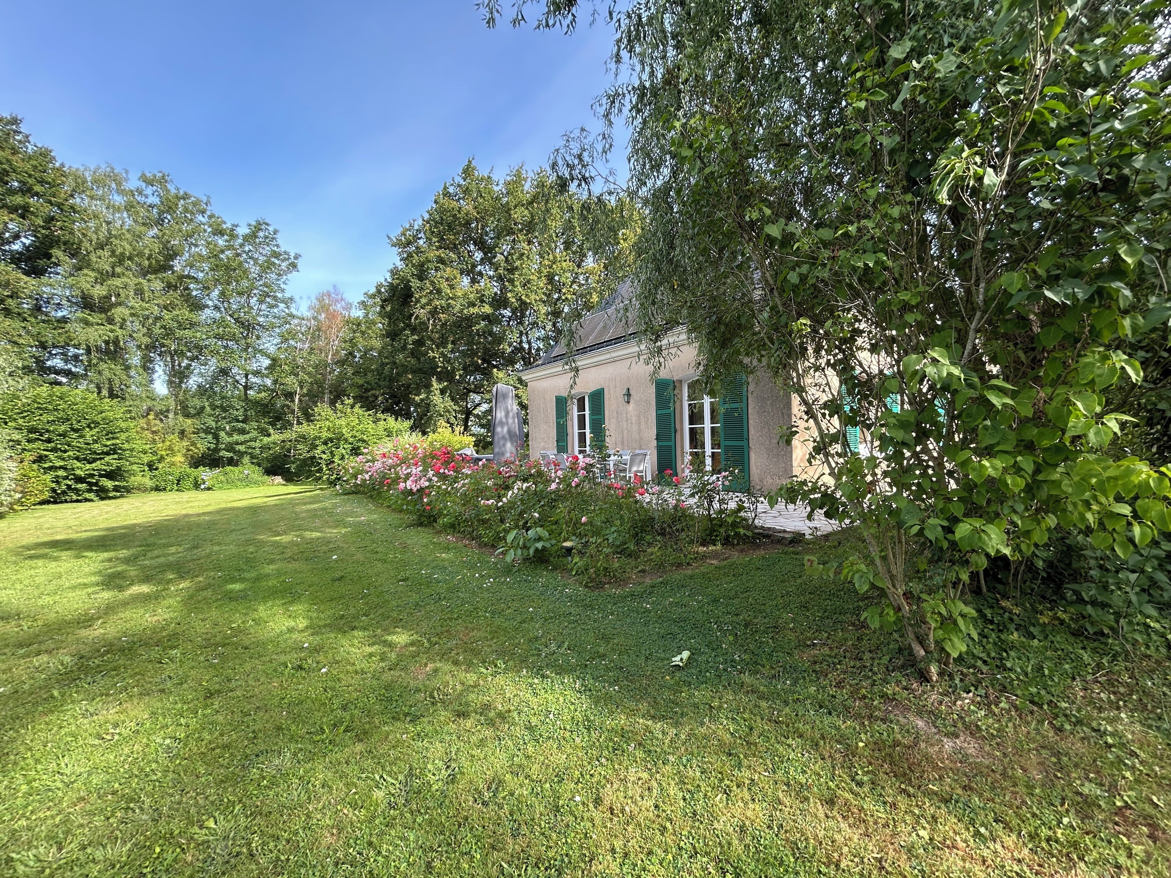 Un bâtiment doté d’un jardin, d’une pelouse et d’un arbre.
