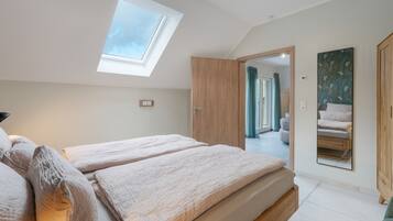 Ein Schlafzimmer mit Oberlicht, einem Bett, einem Kleiderschrank und einem Spiegel.