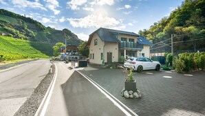 A residential area with a house, a parked car, and a road.