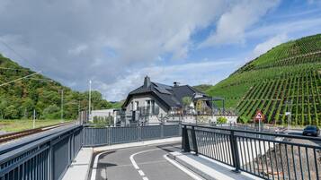 Ein Bahnübergang mit einem Haus und einem Weinberg im Hintergrund.