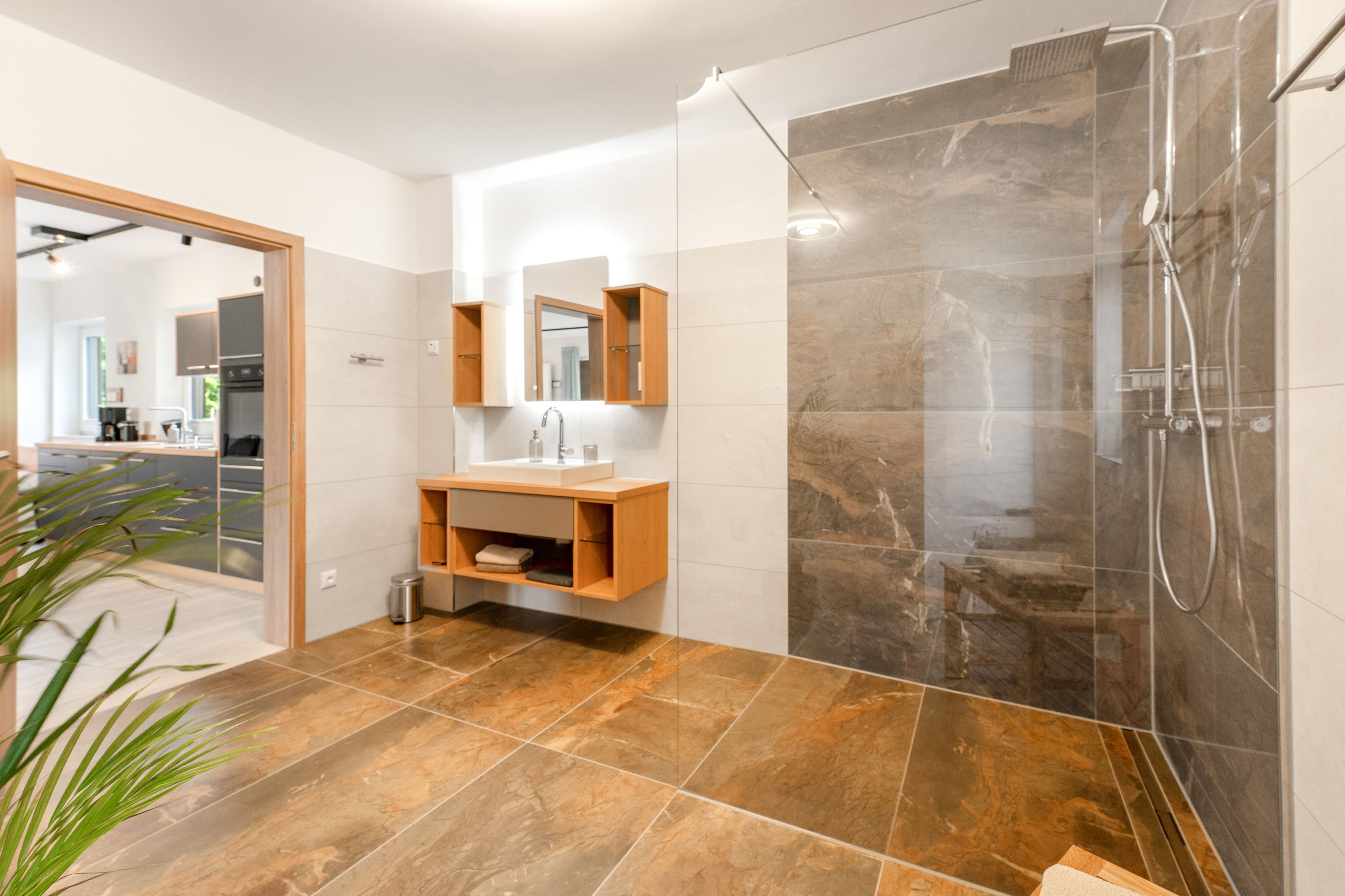 Ein modernes Badezimmer mit Dusche, Waschbecken und Spiegel.