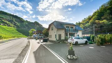 Ein Wohngebiet mit einem Haus, einem geparkten Auto und einer Straße.