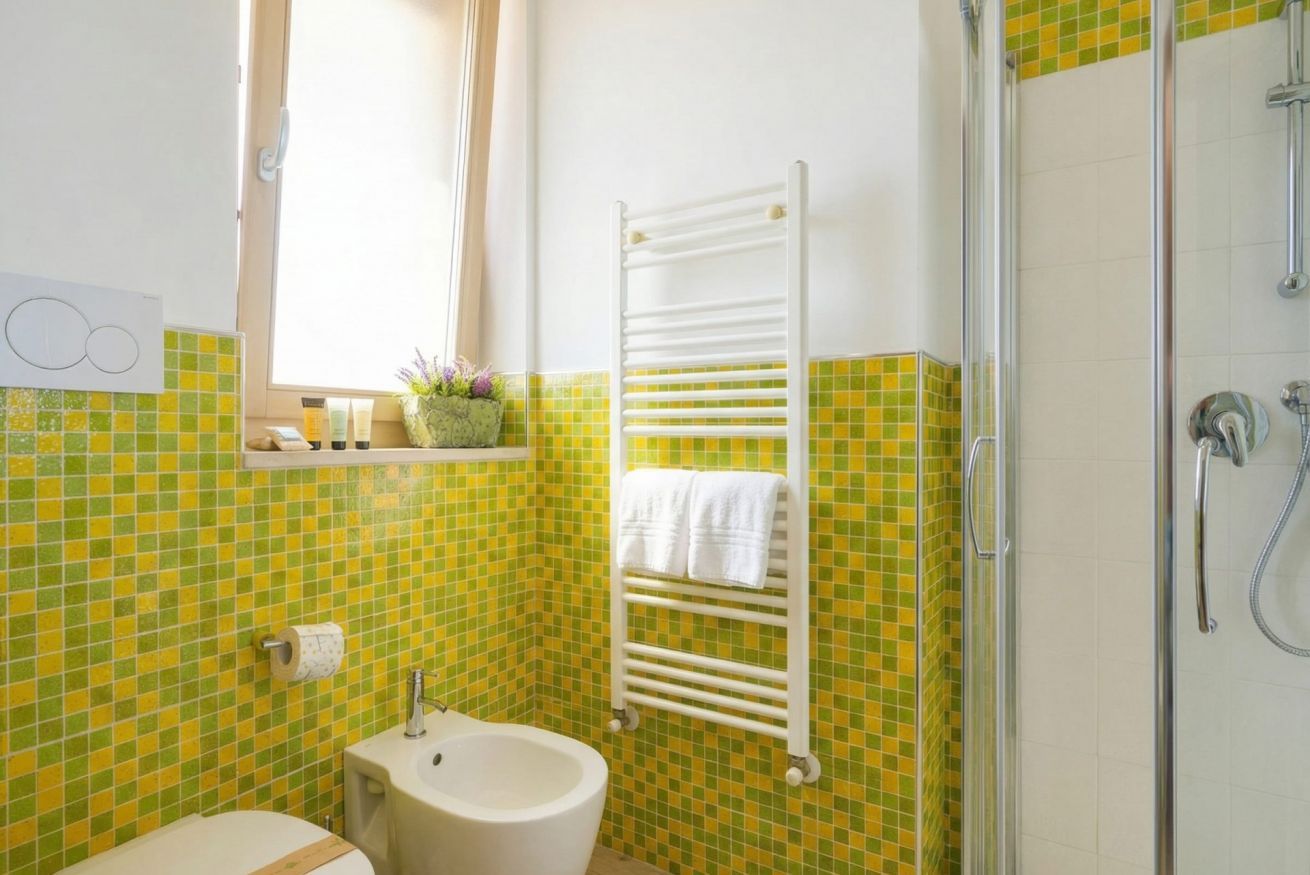 A bathroom with a toilet, sink, and shower.