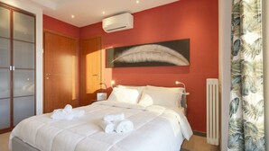 A hotel room with a bed, a large window, a radiator, and a wardrobe.
