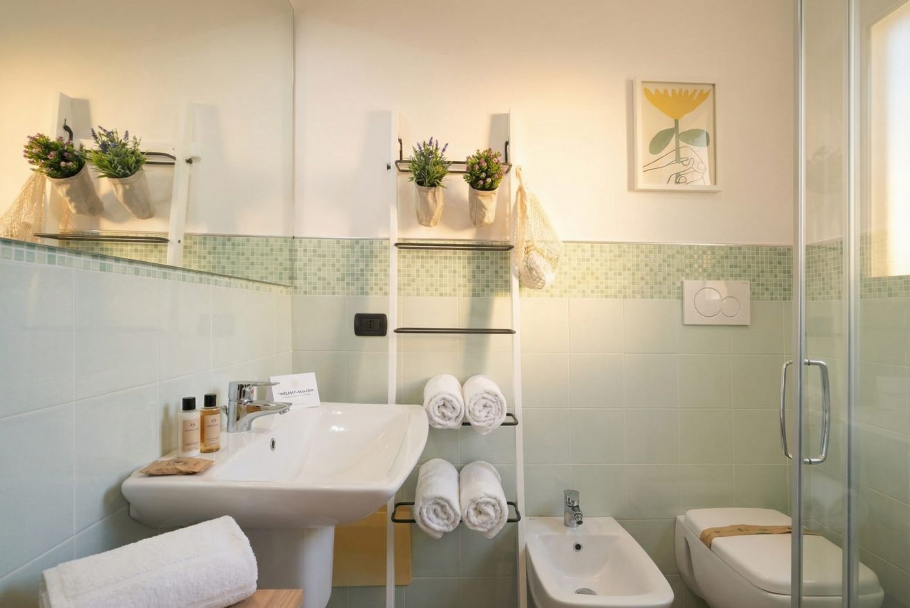 Ein Badezimmer mit Waschbecken, Bidet und Duschkabine aus Glas.