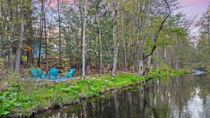 En lugn och vacker plats vid en sjö med utomhusmöbler och stilla vatten.