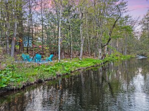 Eine friedliche Uferlandschaft mit Außenbestuhlung und ruhigem See.