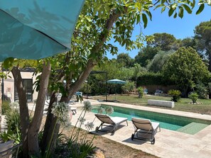 A backyard with a swimming pool, lounge chairs, and a pergola. - COTE D'AZUR - 4-BEDROOM, AIR-CONDITIONED STONE BASTIDE WITH POOL - SLEEPS 8 (Mougins)
