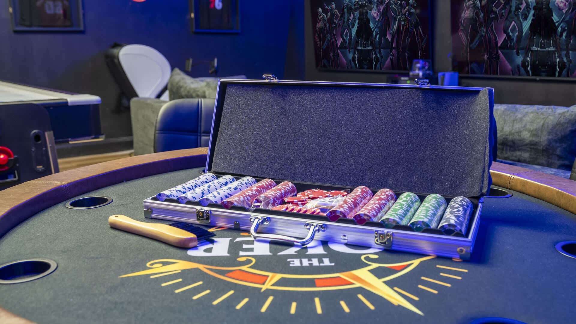 Ein Pokertisch mit einer Box voller Pokerchips und einem Pokerspiel.