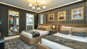 A hotel room with two beds, a large mirror, a chandelier, and framed pictures on the wall. - Luxury Villa Pool Lake View at Balmoral Resort (Haines City)