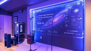 Ein Karaoke-System mit digitalem Display, einem Mikrofonständer und einer Spielmaschine.