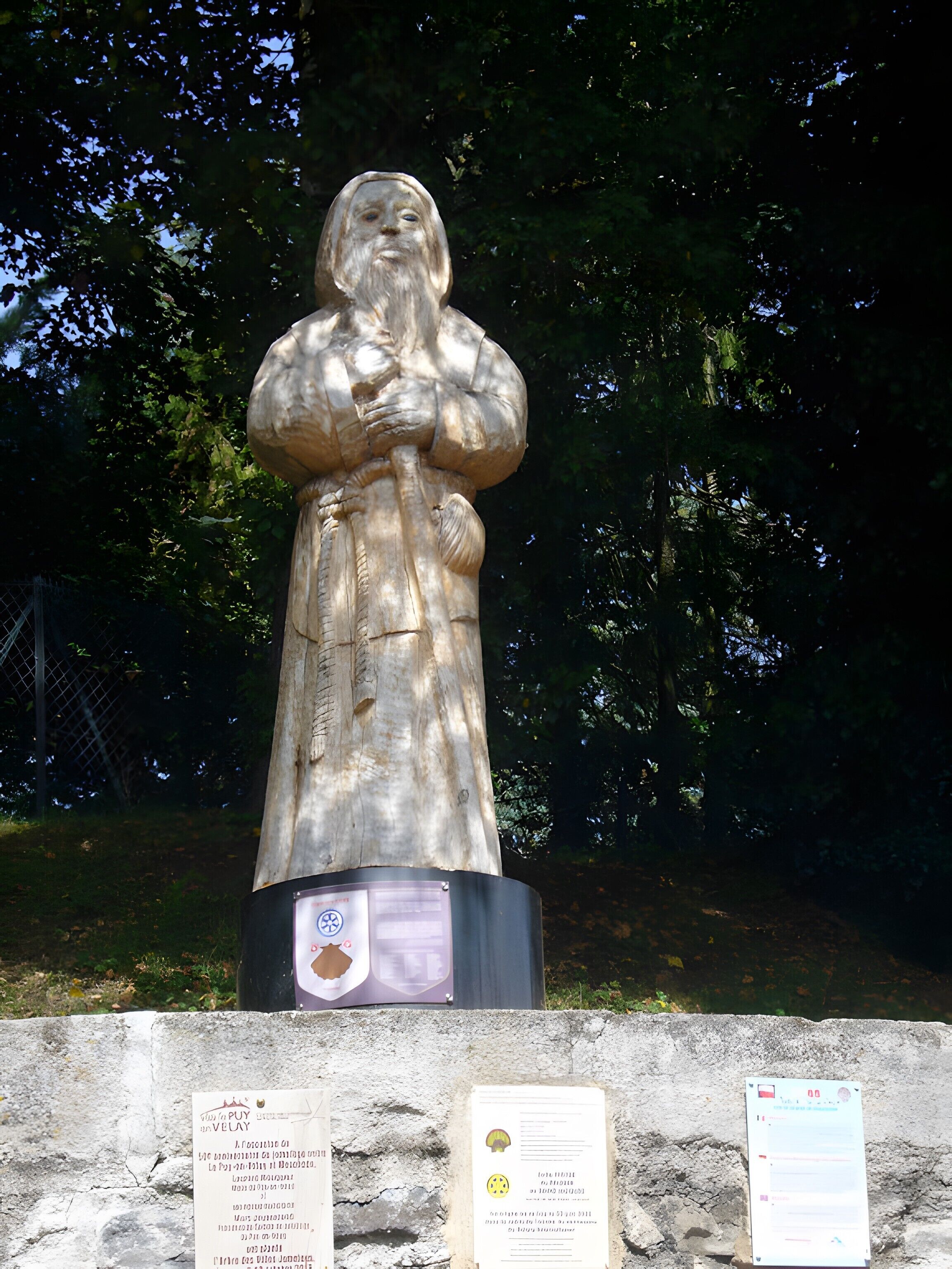 Eine Statue mit einer Gedenktafel davor.