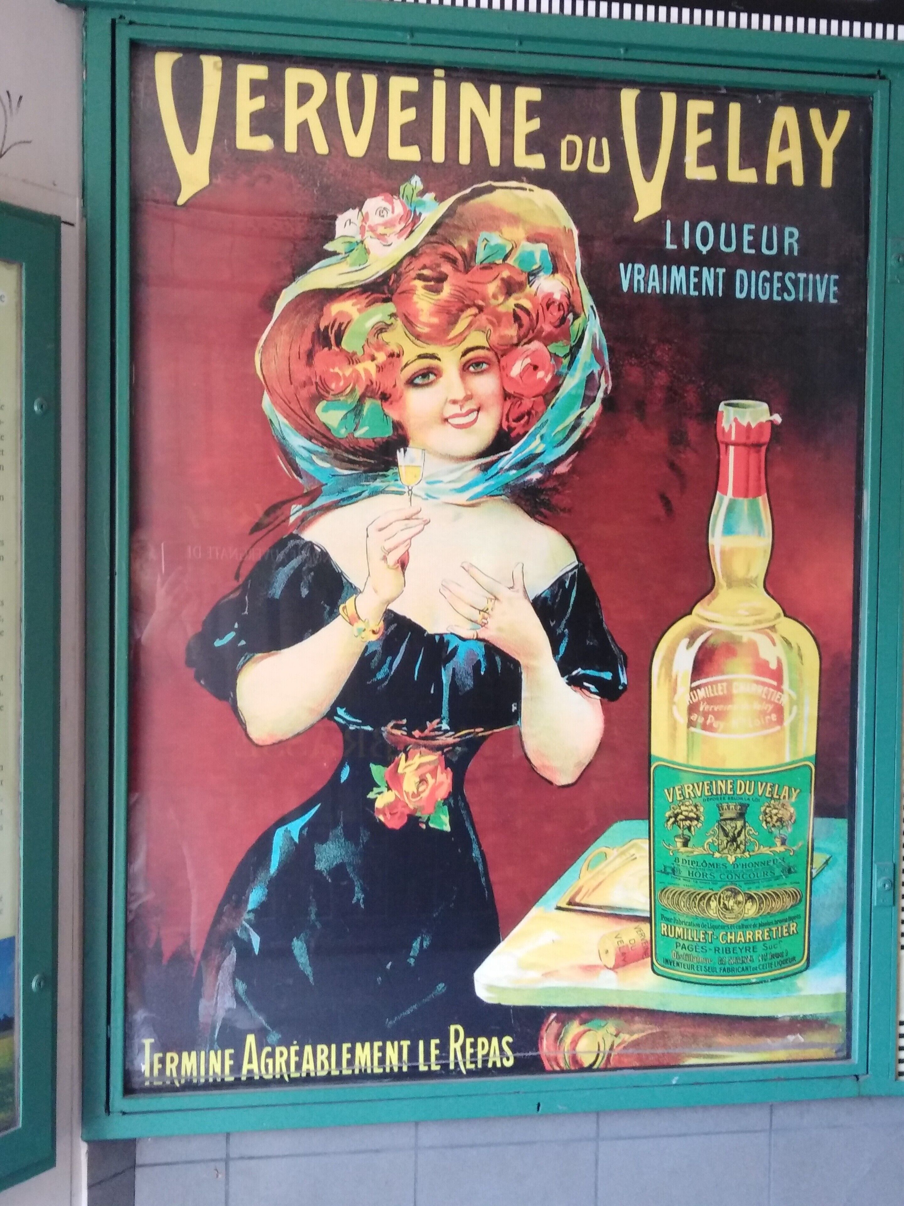 A vintage advertisement for Verveine du Velay liquor featuring a woman in a dress and a bottle of the product.