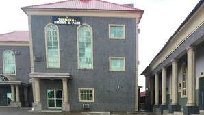 A building with a sign reading 'Terminal Resort & Park.' It has a large entrance with columns and a covered walkway.