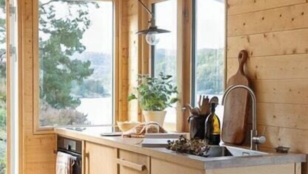 A wooden cabin kitchen with a large window, wooden cabinets, and a sink. - Cottage gem with views of the Oslo Fjord (Akershus)