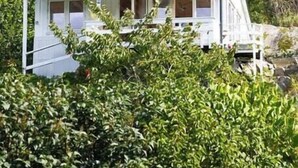 A white building with a dark roof, surrounded by greenery. - Cottage gem with views of the Oslo Fjord (Akershus)