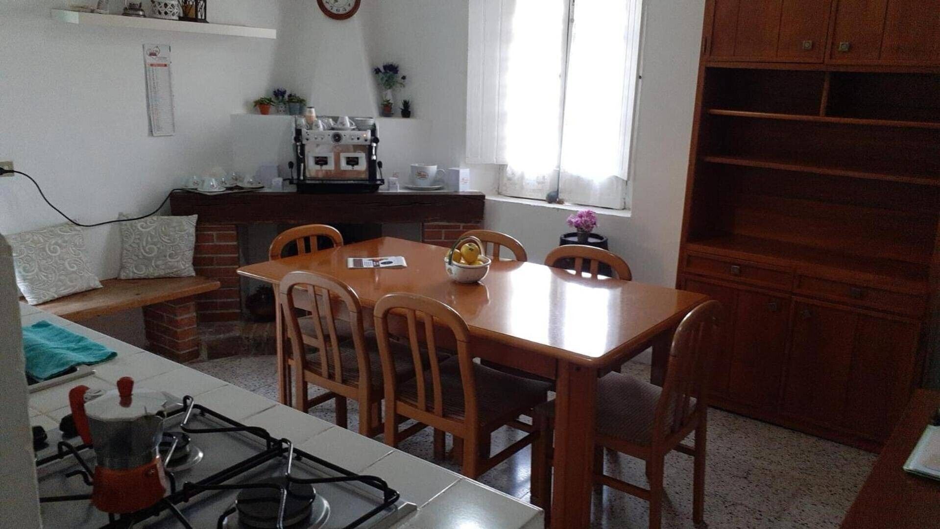 Une cuisine équipée d’une table à manger, de chaises, d’une cuisinière et d’une machine à café.