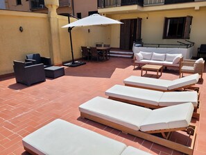 A sunlit outdoor seating area with lounge chairs, a table, and a sofa. - Beach Apt: Huge 80m² Private Terrace, 2 Min Walk to Beach &  Free Parking (Tamariu)