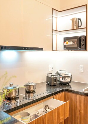 Cozinha moderna com micro-ondas, torradeira e chaleira embutidos na bancada.