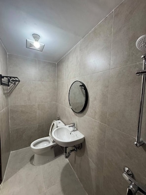 Ein modernes Badezimmer mit Toilette, Waschbecken und Dusche.