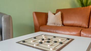 Un juego de mesa sobre una mesa blanca, con un sofá y un cojín al fondo.