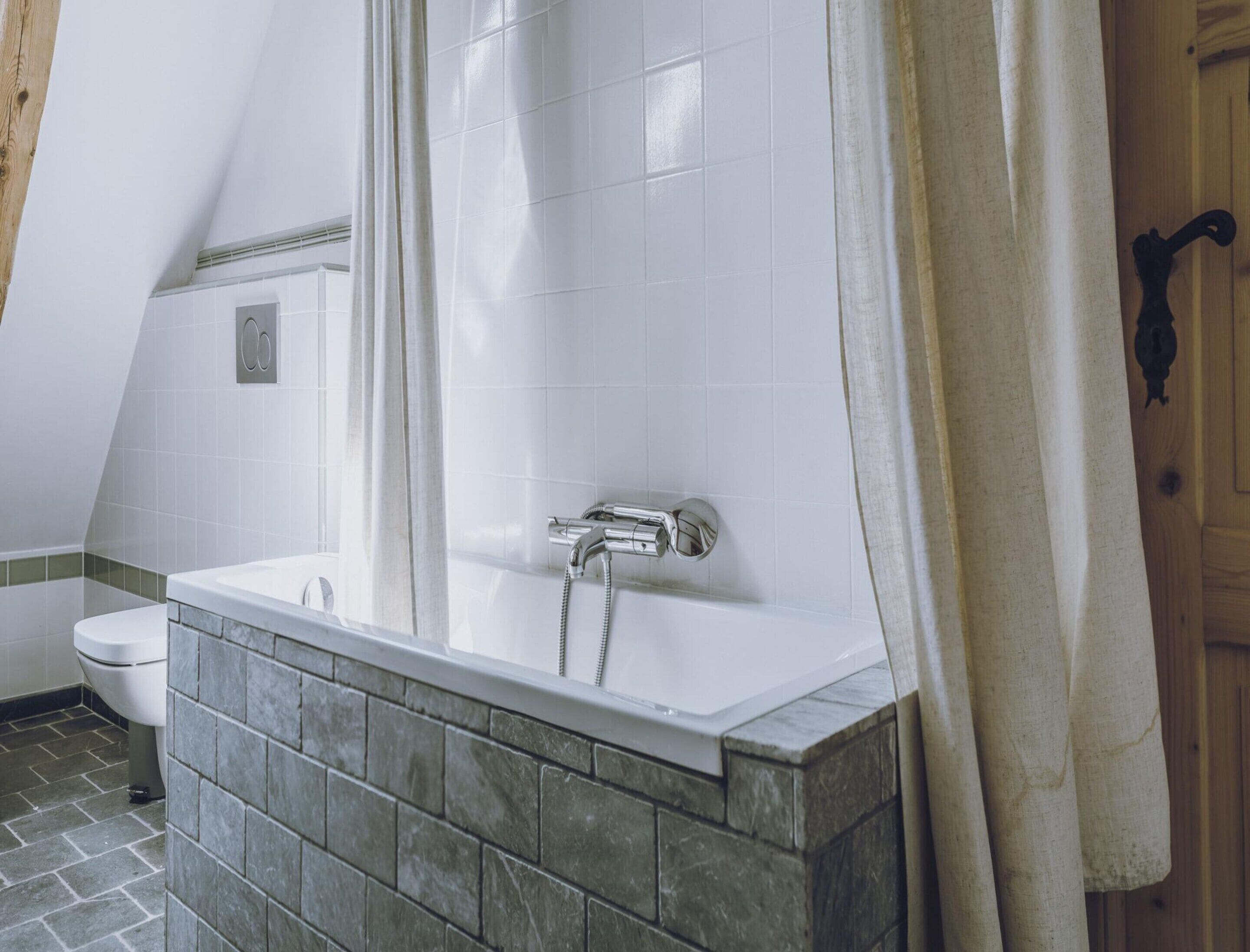 Ein Badezimmer mit Badewanne, Toilette und Duschvorhang.