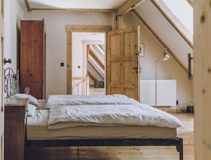 A bedroom with a wooden bed, a metal headboard, a wooden wardrobe, and a radiator. - Riverside Flat for Two Guests (Janowice Wielkie)