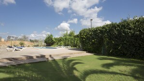 A backyard with a swimming pool, lounge chairs, and solar panels. - Country Home “Servera” with Pool, Wi-Fi, Terrace & Garden (Santanyí)
