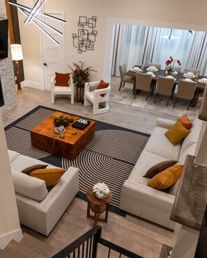 Ein modernes Wohnzimmer mit Couchtisch, Sofas und einem Essbereich mit Tisch für vier Personen.