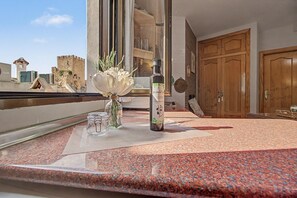 A kitchen counter with a bottle of olive oil, a glass jar, and a vase with flowers.