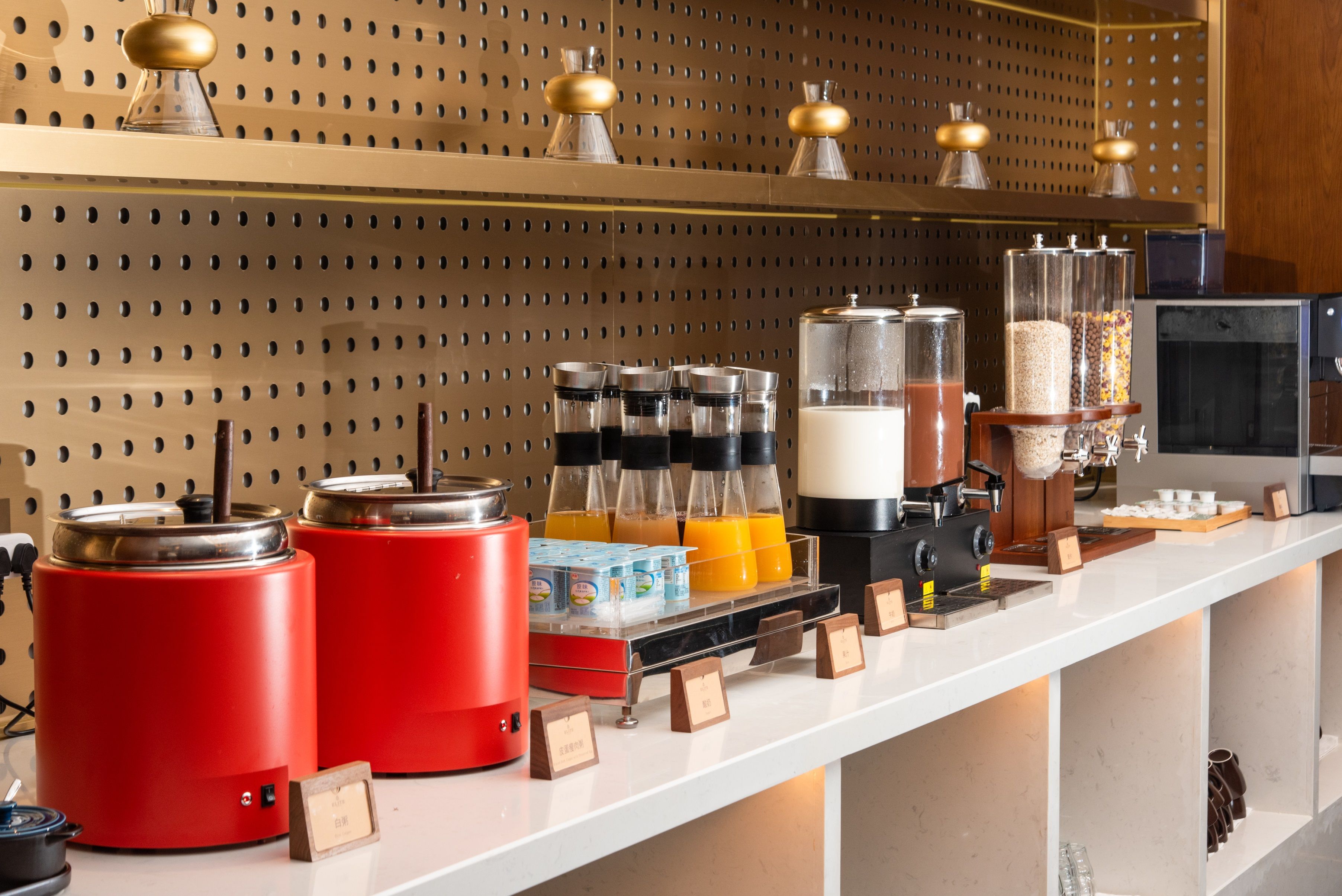 Una estación de café con varias máquinas de café, un espumador de leche y una variedad de granos de café y cartones de leche.