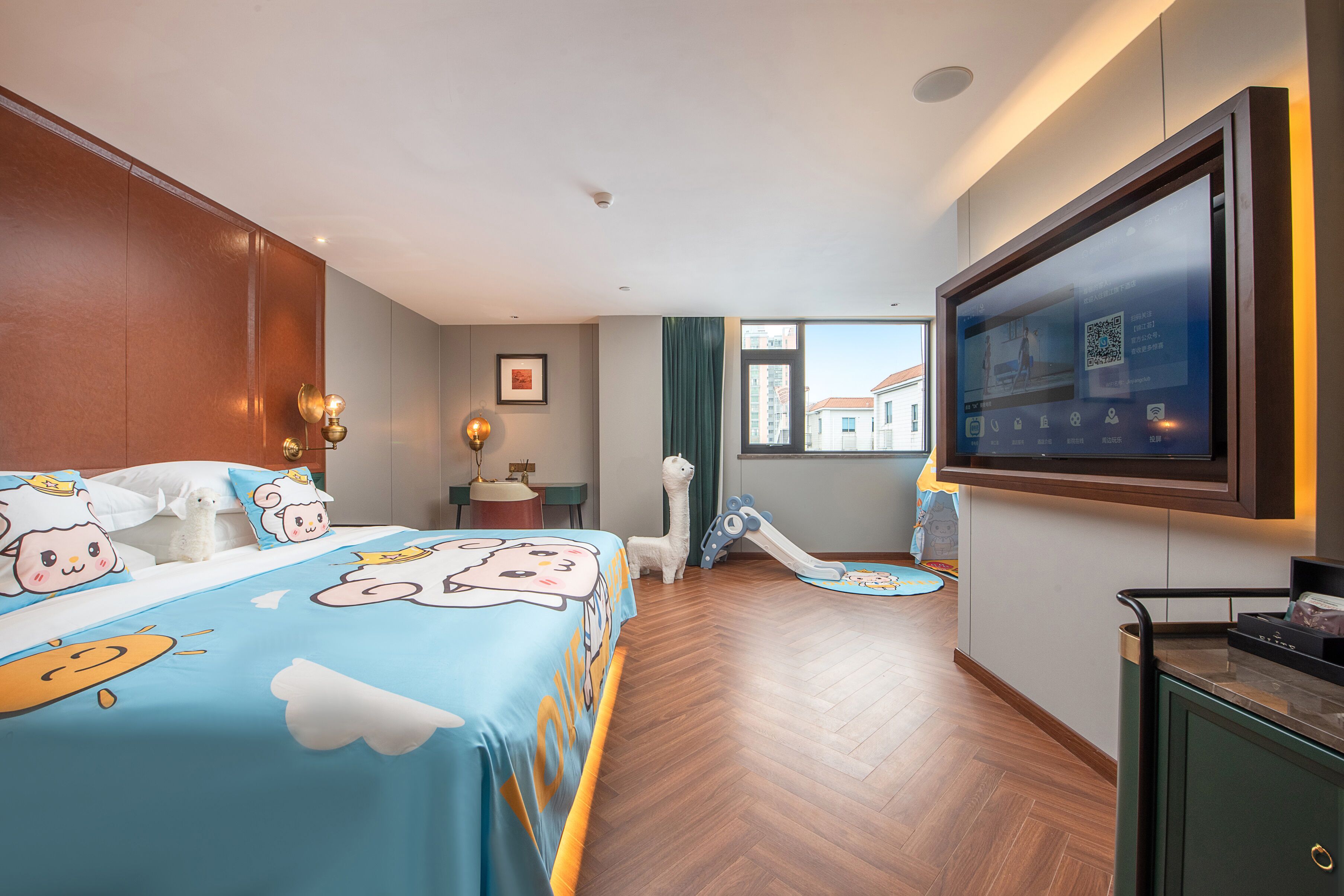 Habitación de hotel con cama, televisor, escritorio, silla, ventana y puerta.