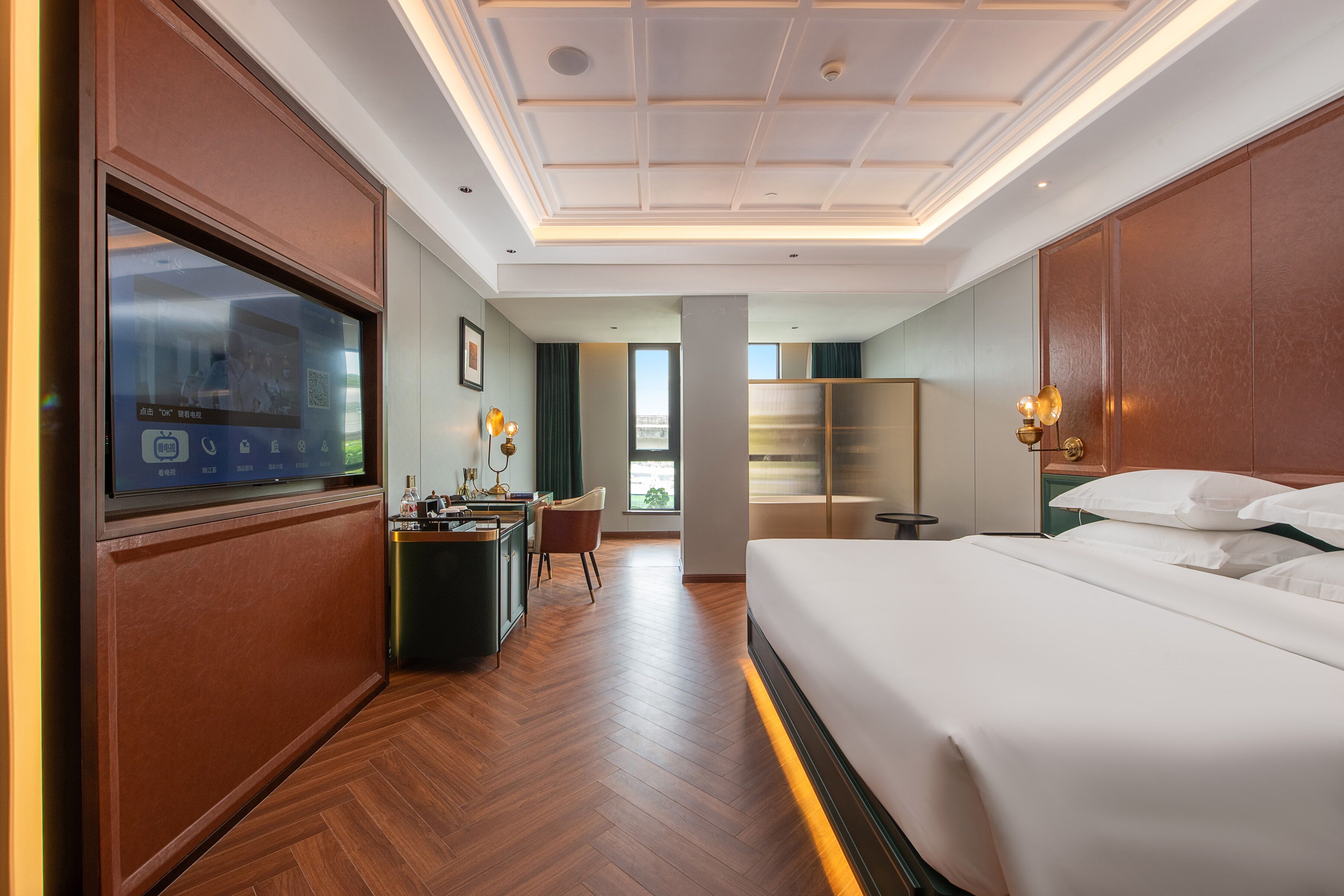 Una habitación de hotel con una cama grande, un escritorio, una silla, un televisor y vistas al exterior.