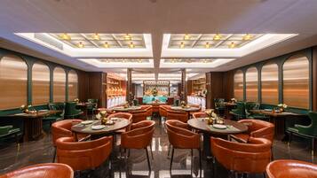 A restaurant with a central bar, multiple dining tables, and booths.