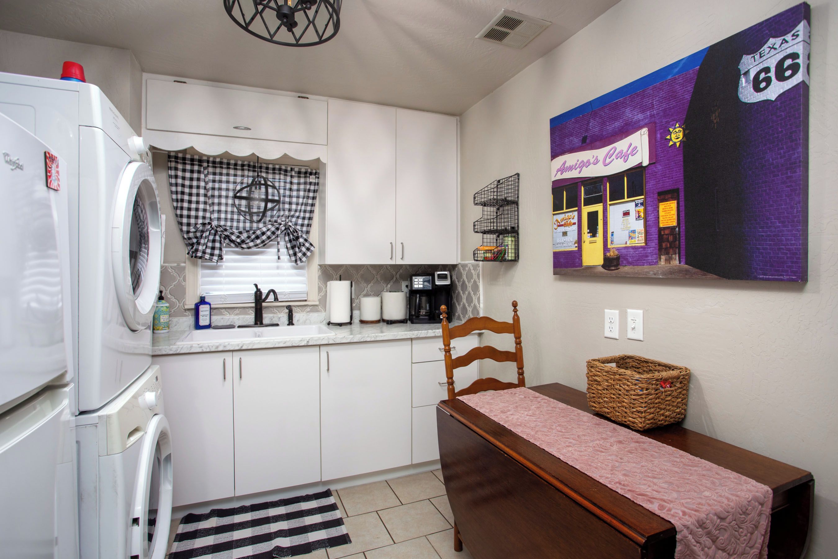 A compact kitchen with a refrigerator, sink, and a dining area with a table and chair.