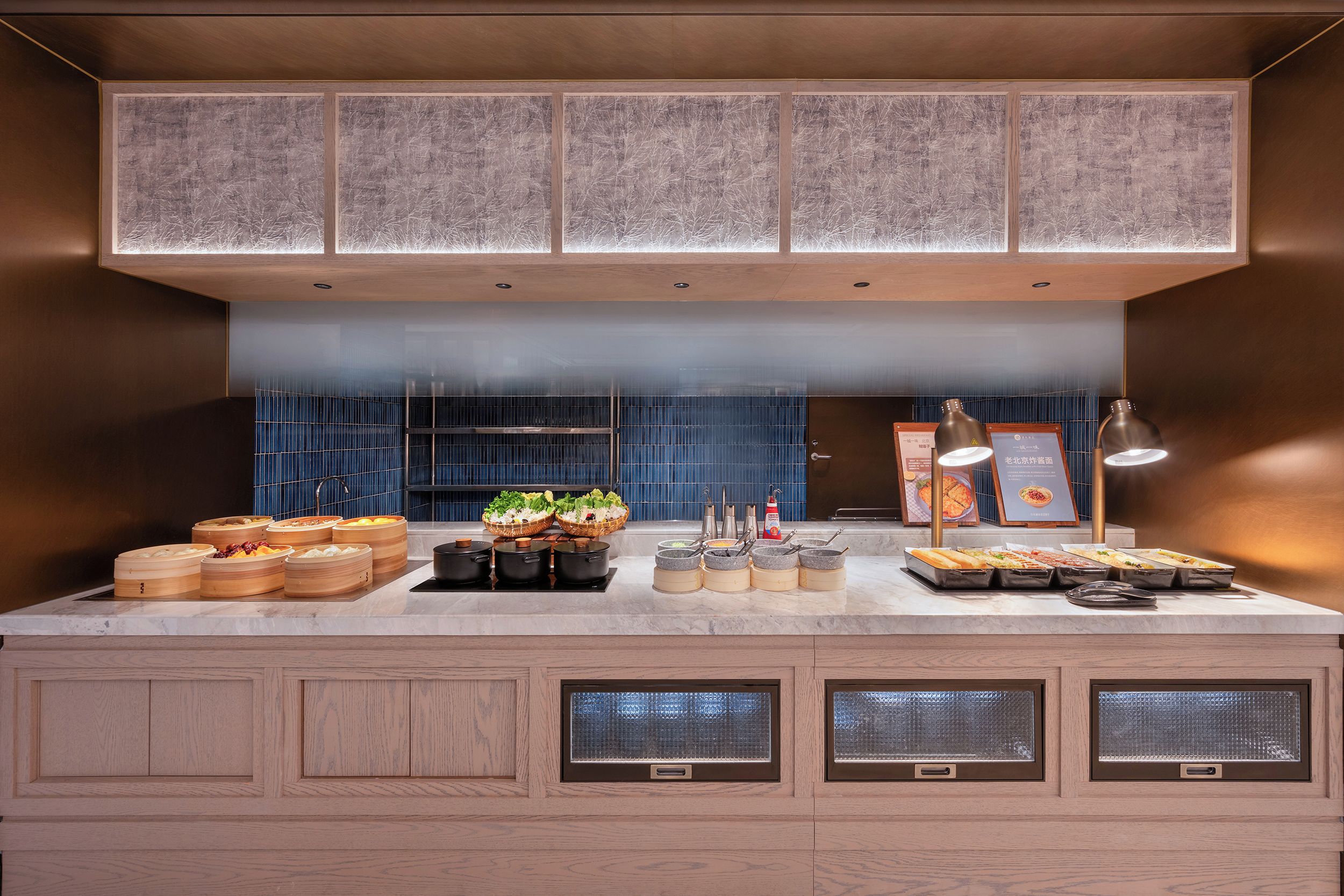 Una cocina moderna con una isla central, electrodomésticos integrados y un salpicadero azul.