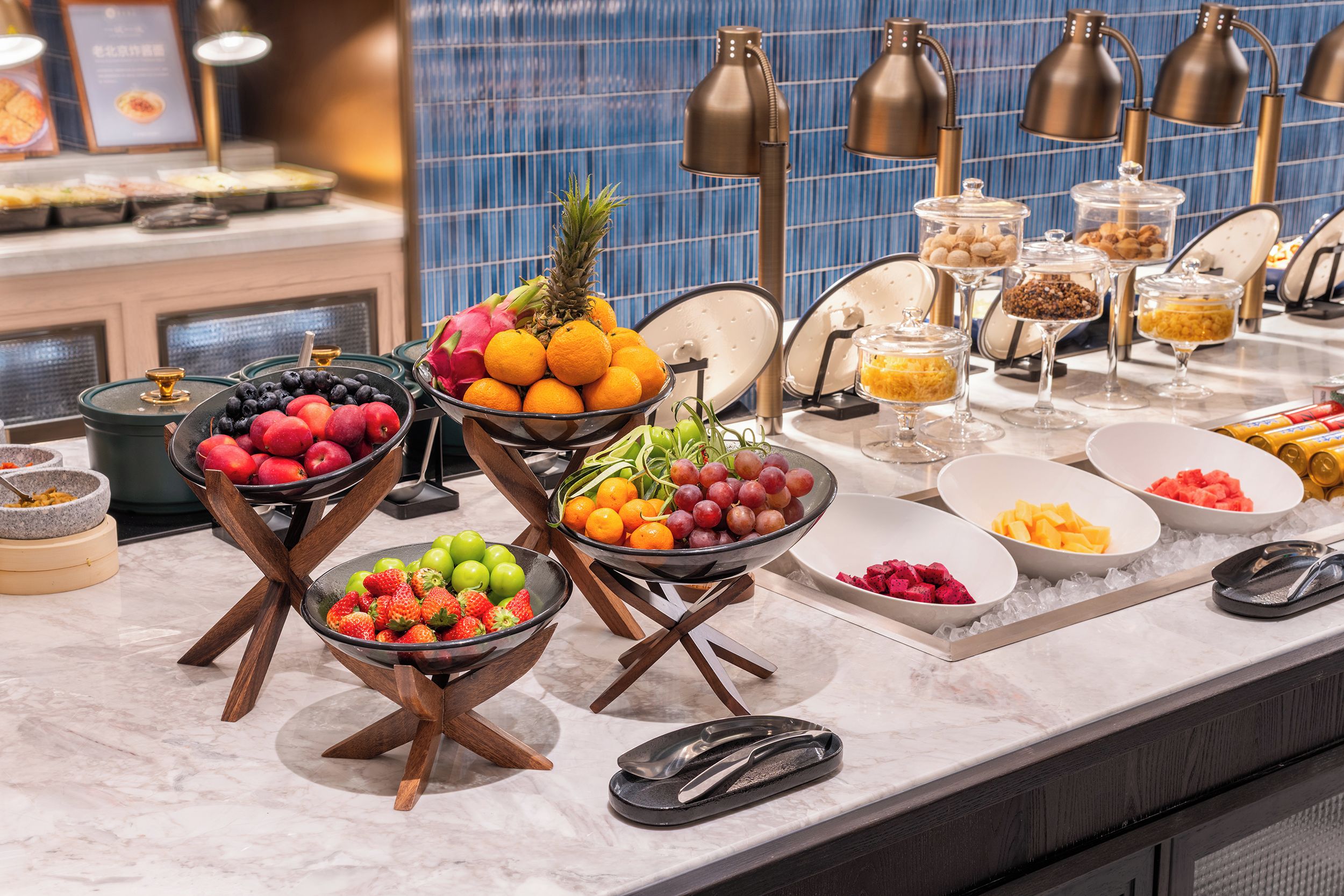 Un bufé con diversas frutas y postres.