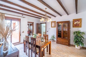 A dining area with wooden furniture, a chandelier, and a potted plant. - Cubo's Urban Plaza Apartment / urban / air conditioning / terrace / free wifi (Alhaurín el Grande)
