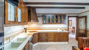 Una cucina con mobili in legno, un'isola centrale e uno schienale rivestito di piastrelle.