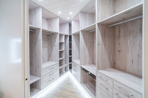 A walk-in closet with open shelving, drawers, and hanging space. - Cubo's Urban Plaza Apartment / urban / air conditioning / terrace / free wifi (Alhaurín el Grande)