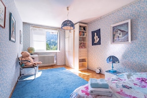 A child's bedroom with a globe, teddy bear, bookshelf, and a bed with a floral bedspread. - Villa Evita Vintage House With Pool in Pohorje (Lovrenc na Pohorju)