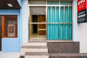 A hotel entrance with a reception desk, a sign indicating booking via an app, and a guest house. - Classic Mathura Railway Junction (Mathura)