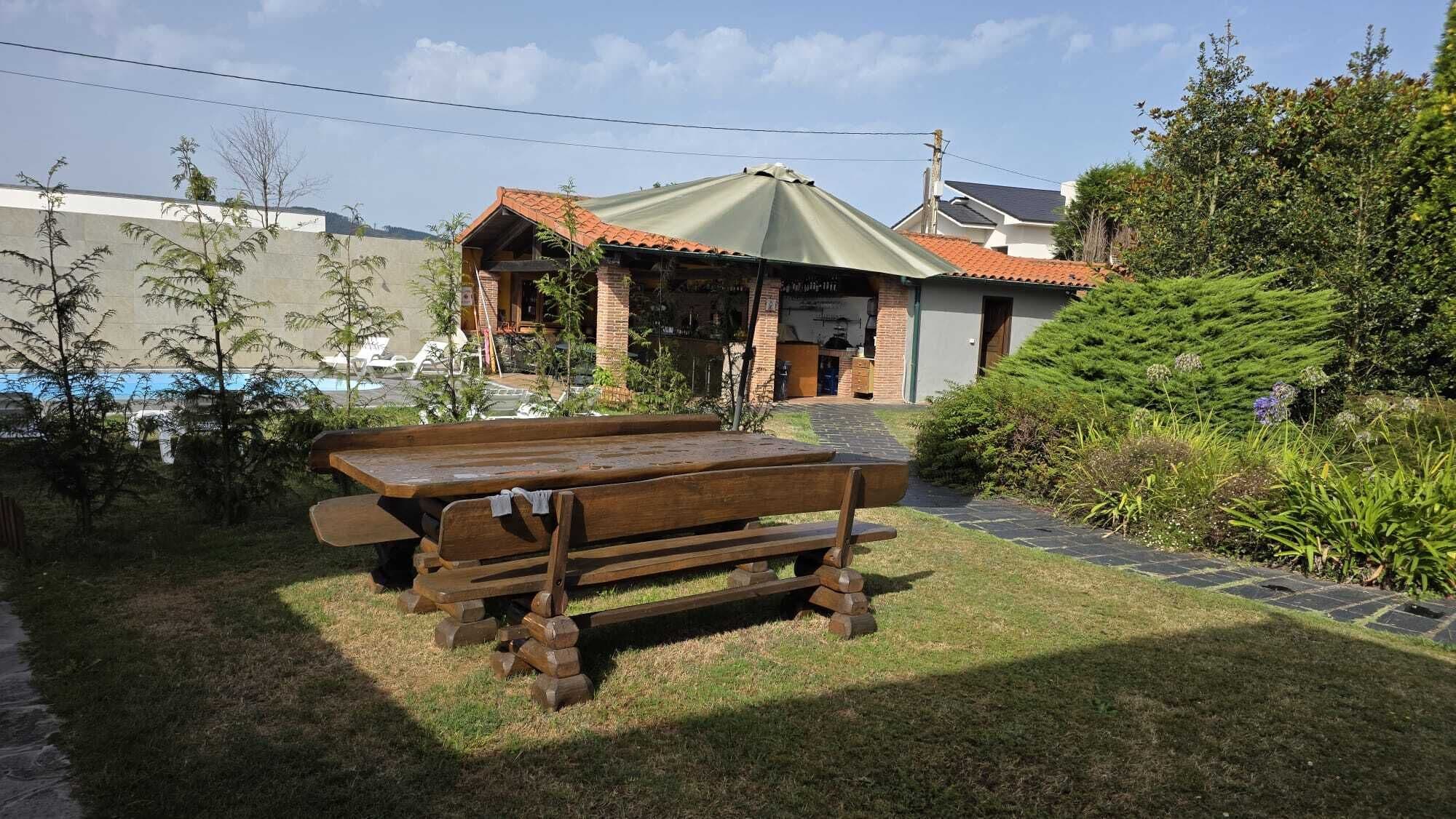 A wooden bench in a garden area with a building in the background.