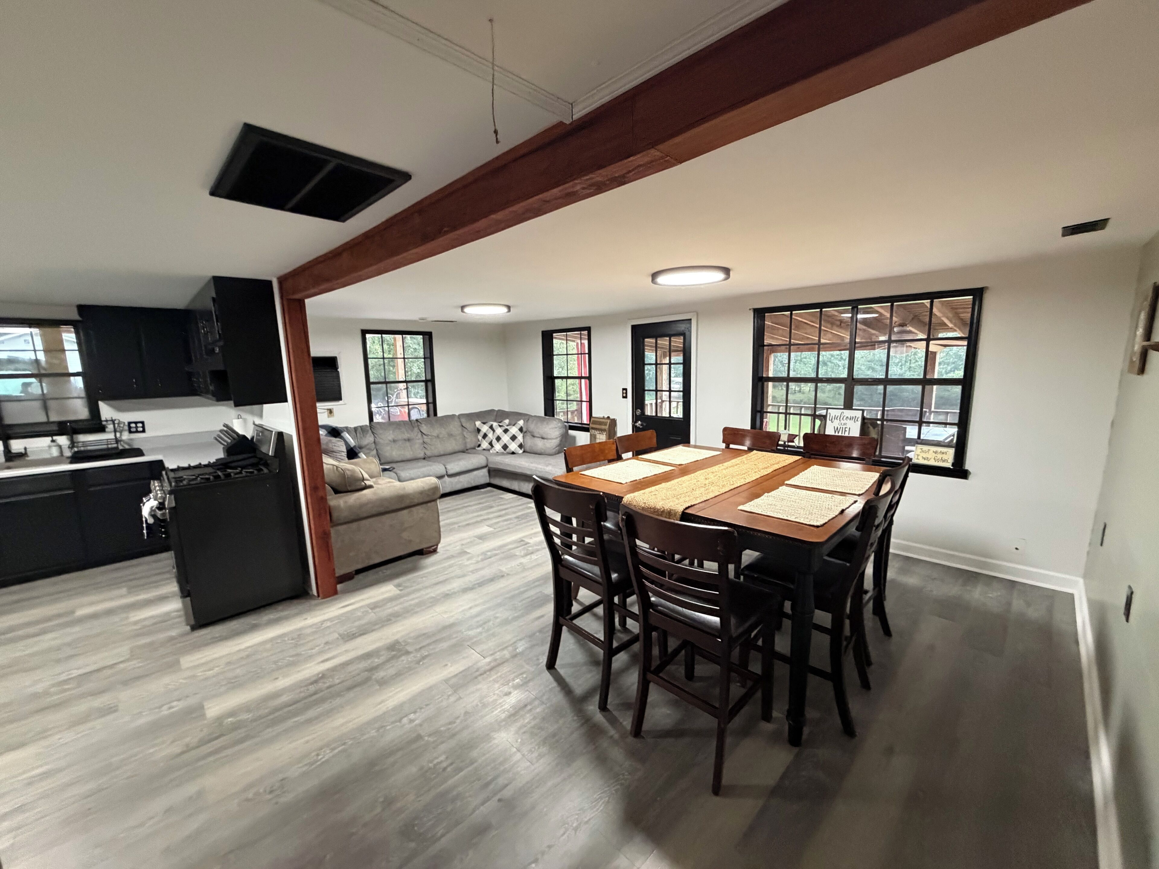 A spacious living area with a dining table, sofa, and kitchen.