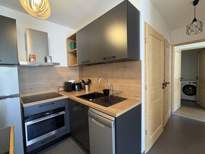 Una cocina moderna con lavavajillas, horno y encimera de madera.