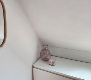 A white bedside table with a glass bottle and a candle. - 1st floor apartment - 2 guests (Luxeuil-les-Bains)