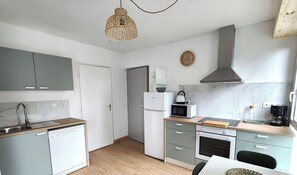 A modern kitchen with grey cabinets, a built-in dishwasher, a microwave, an oven, and a stove. - 1st floor apartment - 2 guests (Luxeuil-les-Bains)