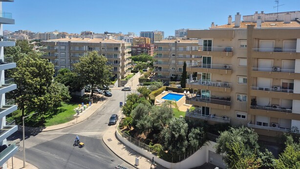 A residential area with multi-story buildings, a curved road, and a swimming pool. - Apartment 'Rocha Waves' with Balcony, Wi-Fi and Air Conditioning (Portimão)