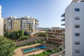 Ein Wohngebäude mit mehreren Balkonen, einem Swimmingpool und Blick aufs Meer.
