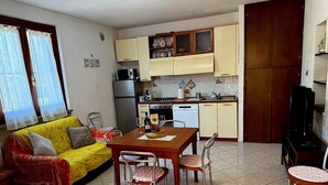 A compact living space with a dining area, kitchenette, and a sofa. - Detached house just a few minutes from the beach (Castiglione della Pescaia)